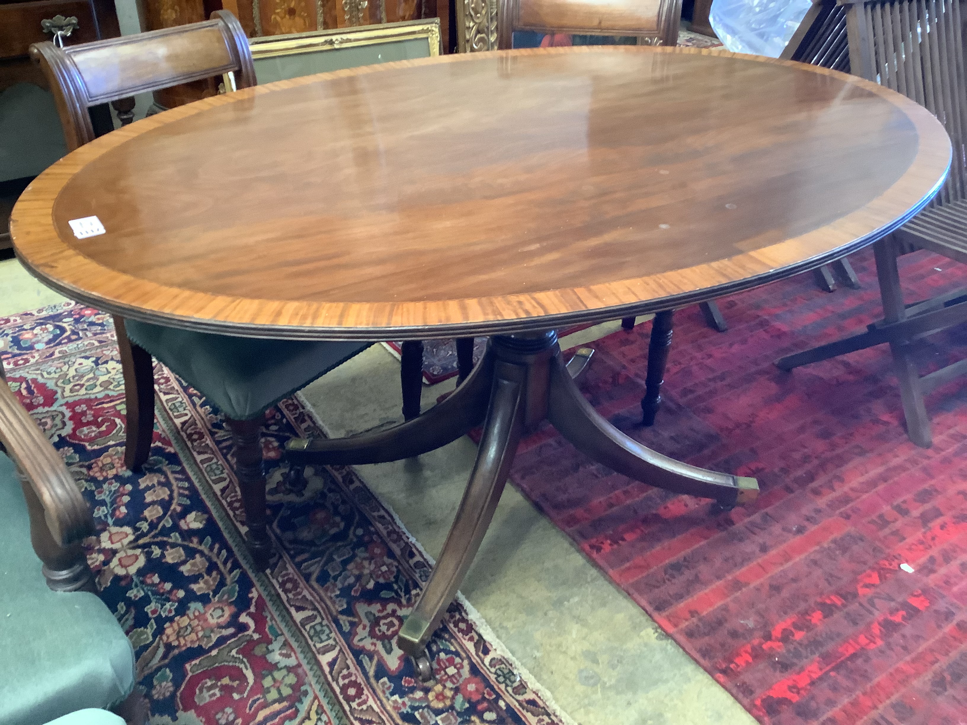 A Regency style oval banded mahogany dining table, length 150cm, depth 103cm, height 76cm